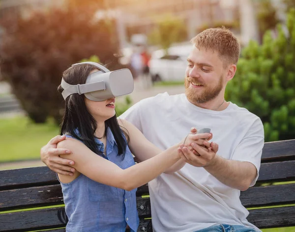 Genç çift sanal gerçeklik gözlükle sokakta bir oyun oynuyor. VR kulaklık.