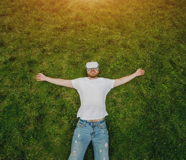 Young Beardy Man Plays Game Glasses Virtual Reality Lying Grass — Stock Photo, Image