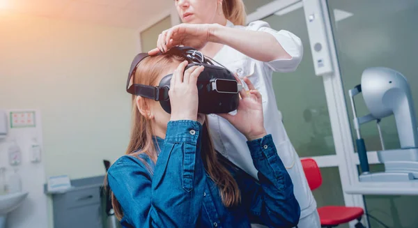 Okulistyka Lekarza Sprawdzanie Wizji Dziewczyna Pomocą Wirtualnej Rzeczywistości Gogle — Zdjęcie stockowe