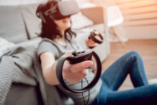 Young girl playing games with virtual reality goggles at home. VR technologies