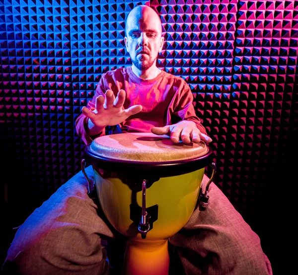 Genç adam djembe ses kayıt stüdyosu içinde oynamaya. Afrika davul