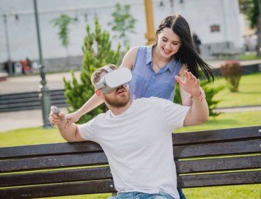 Genç çift sanal gerçeklik gözlükle sokakta bir oyun oynuyor. VR kulaklık.