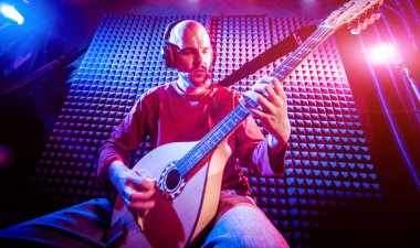 Buzuki ses kayıt stüdyosu olarak oynamaya bir genç adam. Modern arka plan