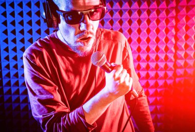 Kayıt stüdyosu olarak bir mikrofon ile şarkıcı söylüyor. Modern arka plan