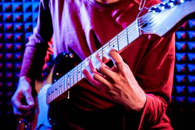 Genç adam gitar ses kayıt stüdyosu içinde oynamaya. Modern arka plan