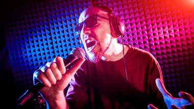 Kayıt stüdyosu olarak bir mikrofon ile şarkıcı söylüyor. Modern arka plan