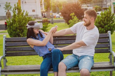 Genç çift sanal gerçeklik gözlükle sokakta bir oyun oynuyor. VR kulaklık.