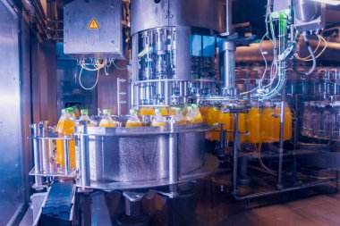 Otomatik Dolum Makinası su Plastik Pet şişe dökülen. Bira üretim. Endüstriyel arka plan.