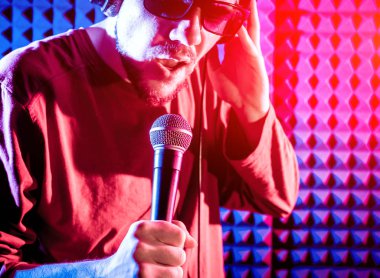 Kayıt stüdyosu olarak bir mikrofon ile şarkıcı söylüyor. Modern arka plan