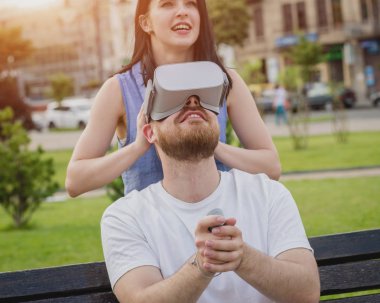 Genç çift sanal gerçeklik gözlükle sokakta bir oyun oynuyor. VR kulaklık.