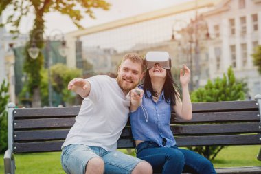 Genç çift sanal gerçeklik gözlükle sokakta bir oyun oynuyor. VR kulaklık.