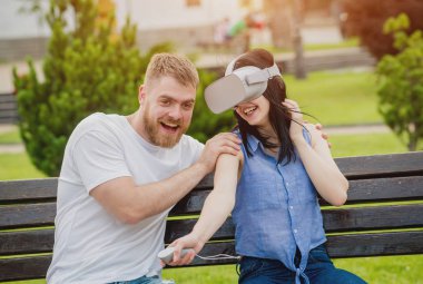 Genç çift sanal gerçeklik gözlükle sokakta bir oyun oynuyor. VR kulaklık.