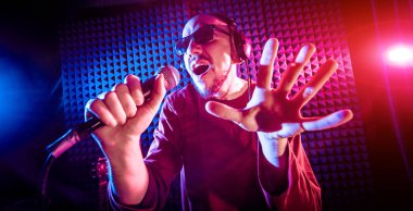 Kayıt stüdyosu olarak bir mikrofon ile şarkıcı söylüyor. Modern arka plan