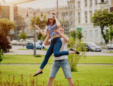 Genç çift sanal gerçeklik gözlükle sokakta bir oyun oynuyor. VR kulaklık.