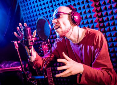 Kayıt stüdyosu olarak bir mikrofon ile şarkıcı söylüyor. Modern arka plan