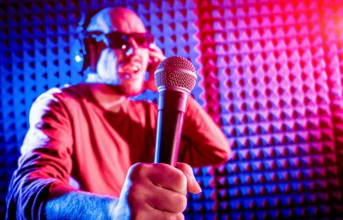 Kayıt stüdyosu olarak bir mikrofon ile şarkıcı söylüyor. Modern arka plan