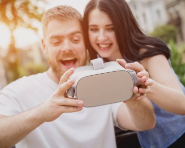 Genç çift sanal gerçeklik gözlükle sokakta bir oyun oynuyor. VR kulaklık.