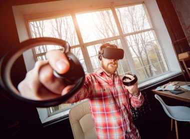 Sanal gerçeklik giyen genç sakallı adam ofiste gözlükler