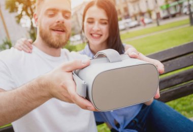 Genç çift sanal gerçeklik gözlükle sokakta bir oyun oynuyor. VR kulaklık.