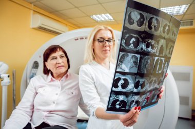 X-ışını arayan yaşlı bir kadın hasta ile radyolog. Arka plan