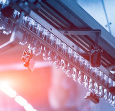 Otomatik Dolum Makinası su Plastik Pet şişe dökülen. Bira üretim. Endüstriyel arka plan.