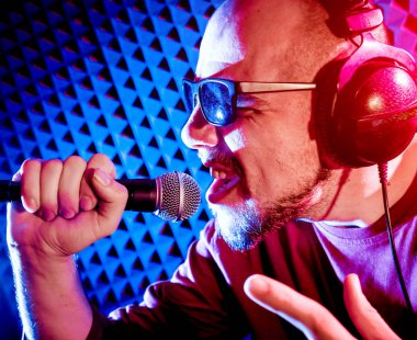 Kayıt stüdyosu olarak bir mikrofon ile şarkıcı söylüyor. Modern arka plan