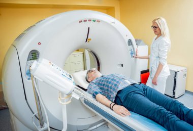 Doktor ve hasta hastanede bilgisayarlı tomografi odasında. Tıbbi donatımı.