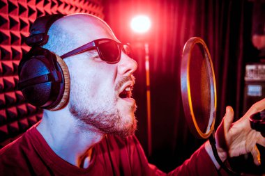 Kayıt stüdyosu olarak bir mikrofon ile şarkıcı söylüyor. Modern arka plan