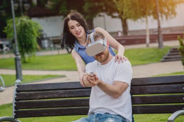 Genç çift sanal gerçeklik gözlükle sokakta bir oyun oynuyor. VR kulaklık.