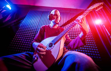 Buzuki ses kayıt stüdyosu olarak oynamaya bir genç adam. Modern arka plan