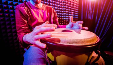 Genç adam djembe ses kayıt stüdyosu içinde oynamaya. Afrika davul