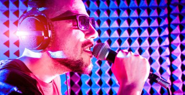 Kayıt stüdyosu olarak bir mikrofon ile şarkıcı söylüyor. Modern arka plan