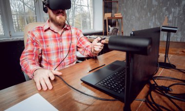 Sanal gerçeklik giyen genç sakallı adam ofiste gözlükler