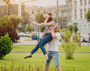 Genç çift sanal gerçeklik gözlükle sokakta bir oyun oynuyor. VR kulaklık.