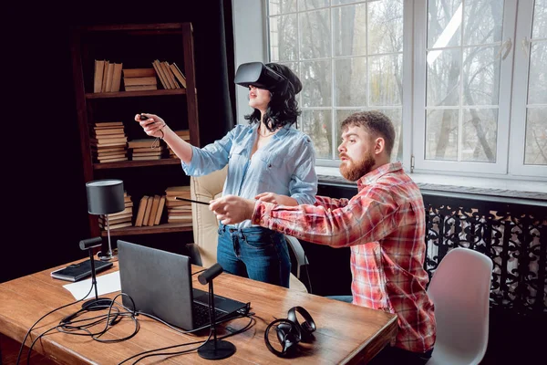 Genç adam ve kız çalış bir oyun sanal gerçeklik gözlükleri ile dolap odası. 