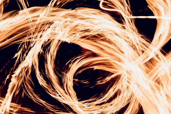 Gösteri yangın. Karanlıkta ateş performans gösteren genç adam.