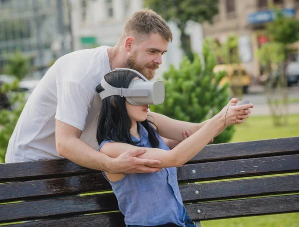 Genç çift sanal gerçeklik gözlükle sokakta bir oyun oynuyor. VR kulaklık.