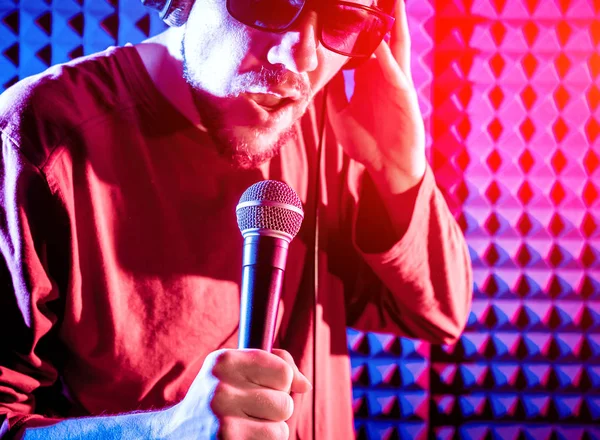 Kayıt stüdyosu olarak bir mikrofon ile şarkıcı söylüyor. Modern arka plan