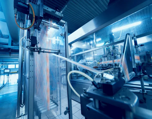 Otomatik Dolum Makinası su Plastik Pet şişe dökülen. Bira üretim. Endüstriyel arka plan.