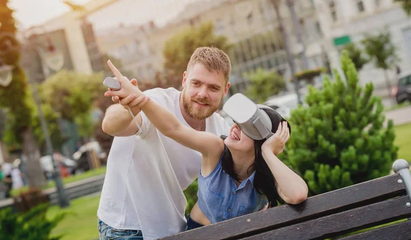 Genç çift sanal gerçeklik gözlükle sokakta bir oyun oynuyor. VR kulaklık.