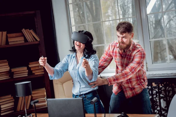 Genç adam ve kız çalış bir oyun sanal gerçeklik gözlükleri ile dolap odası. 