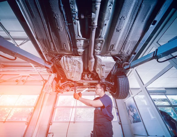 Araba tamircisi araba süspansiyon kaldırdı otomobil tamir hizmet istasyonu incelenmesi. Arka plan