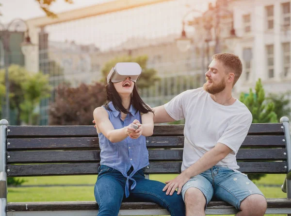 Genç çift sanal gerçeklik gözlükle sokakta bir oyun oynuyor. VR kulaklık.