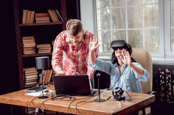 Genç adam ve kız çalış bir oyun sanal gerçeklik gözlükleri ile dolap odası. 