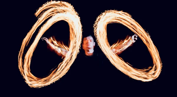 Gösteri yangın. Karanlıkta ateş performans gösteren genç adam.