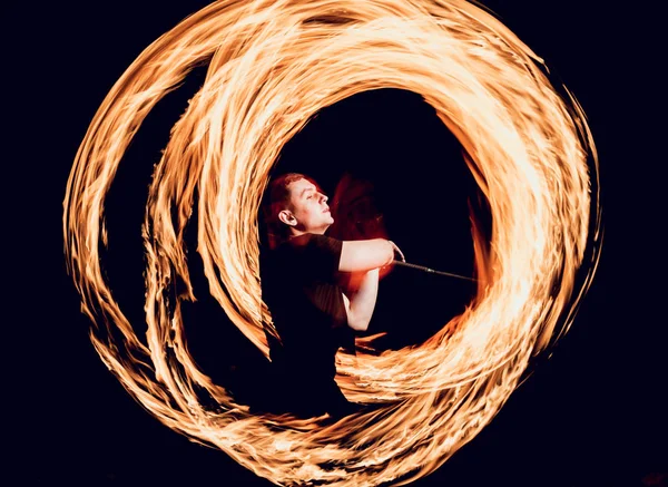 Gösteri yangın. Karanlıkta ateş performans gösteren genç adam.