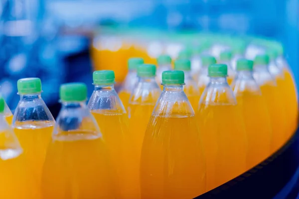 ジュースや水のボトルとコンベヤです 飲料工場の設備機器 バック グラウンド — ストック写真