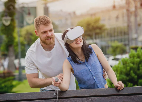 Genç çift sanal gerçeklik gözlükle sokakta bir oyun oynuyor. VR kulaklık.