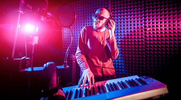 Ses kayıt stüdyosunda piyano genç adam. Modern arka plan