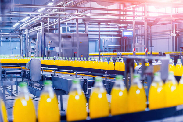 Beverage factory interior. Conveyor with bottles for juice or water. Modern equipments